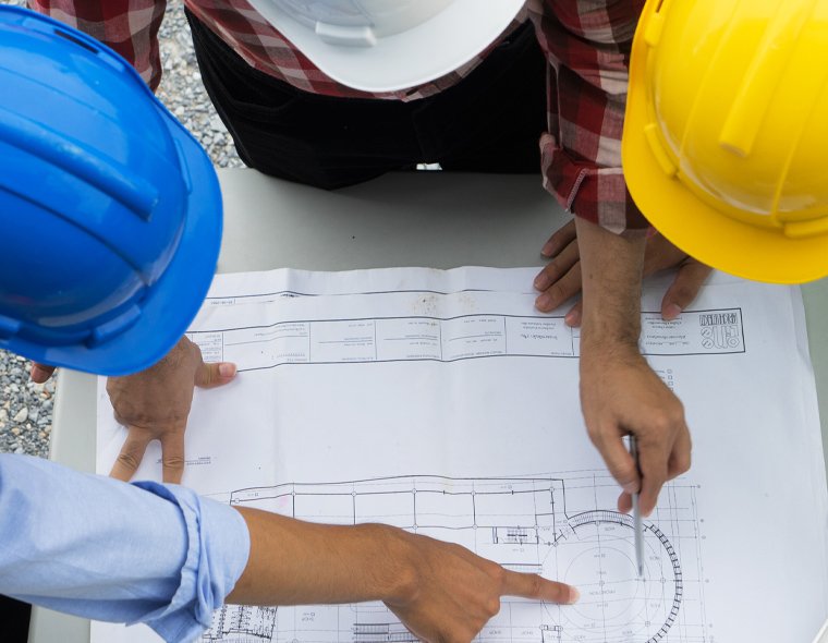 group of engineers looking at a blue print